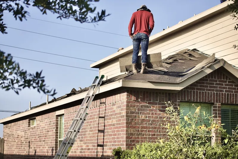 Professional roofer working on a residential roof in Colony Crossing